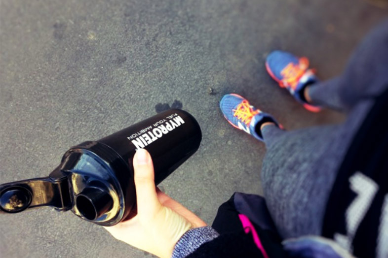 Femme avec un shaker de protéines en poudre