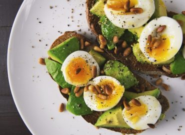 Toast à l'avocat avec des oeufs mollets et des pignons