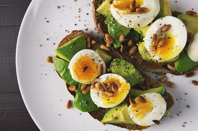 Toast à l'avocat avec des oeufs mollets et des pignons