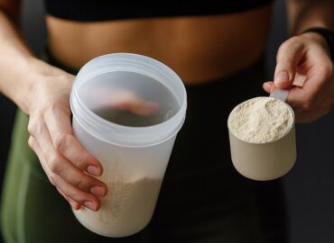 femme qui tient un shaker de whey dans sa main