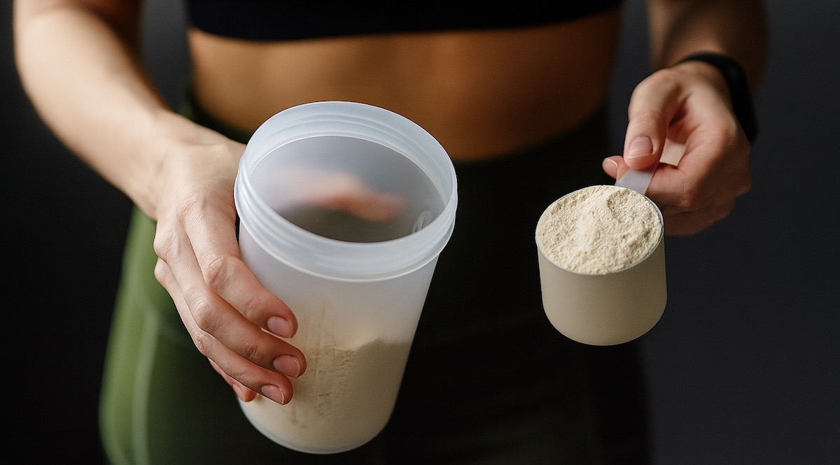 femme qui tient un shaker de whey dans sa main